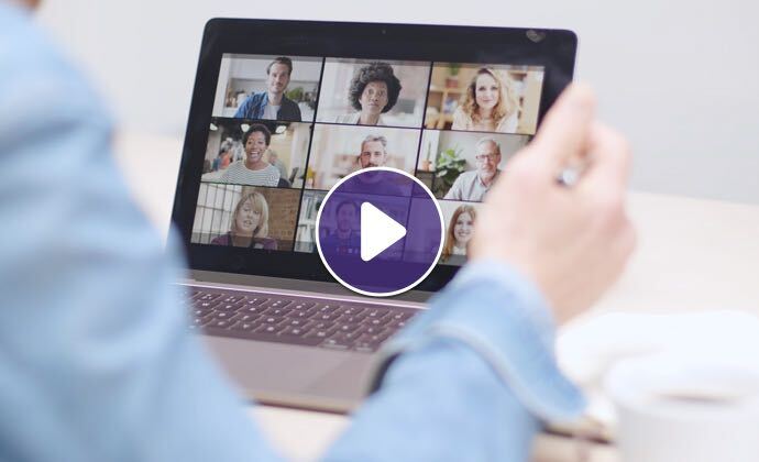 A laptop shows a videoconference call