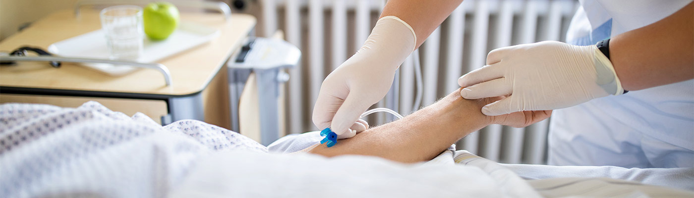 A clinician helps with a patient's IV line