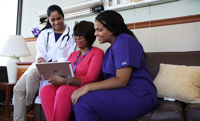 Three VITAS team members look at information on an iPad