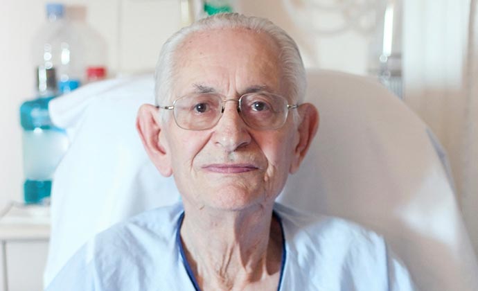 An older man in a hospital gown.