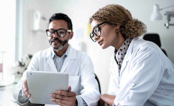 Two healthcare professionals view an iPad
