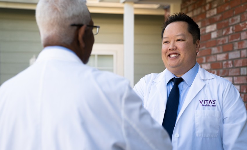 A clinician talks with a patient as both sit on a sofa