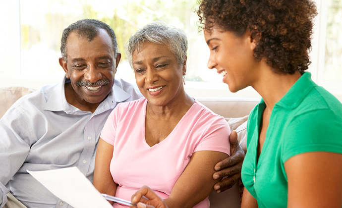 A couple looks at paperwork while their daughter points to it