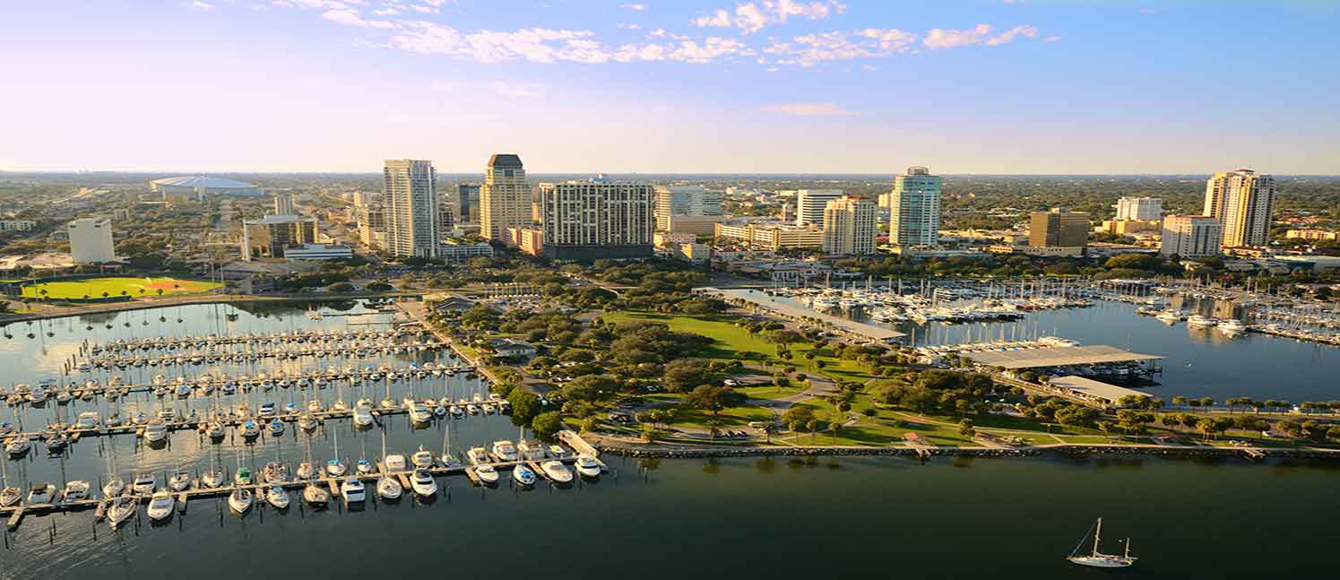 A view of a waterfront with marinas, a park and high-rise buildings
